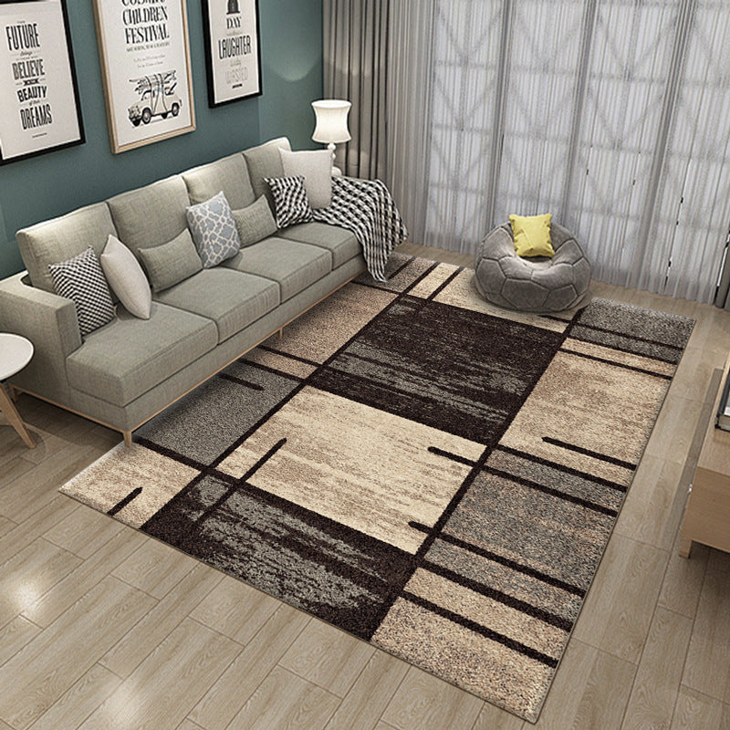 Modern living room with a patterned rug, gray sofa, and decorative pillows.