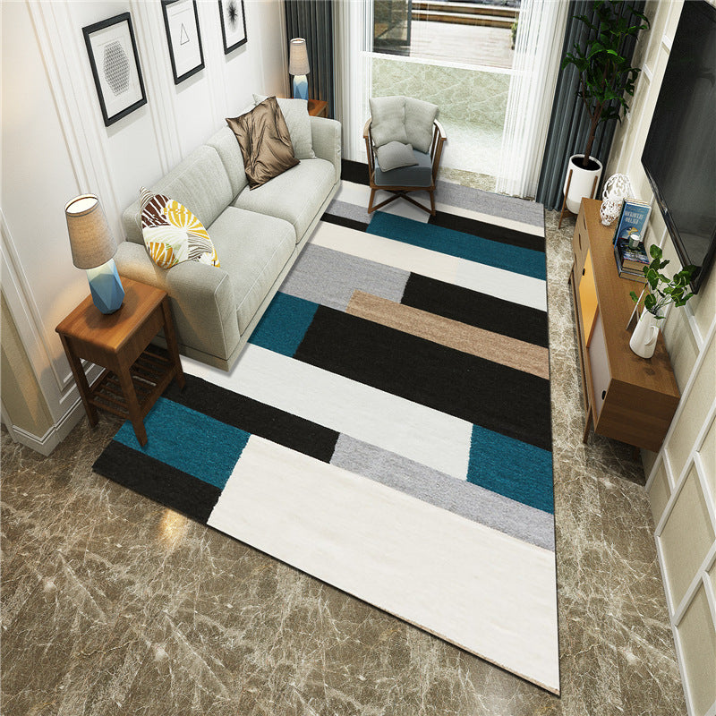 Living room with a geometric patterned rug, sofa, and decor items.