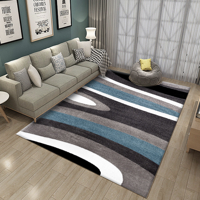 Living room with a striped area rug, sofa, and decorative pillows.