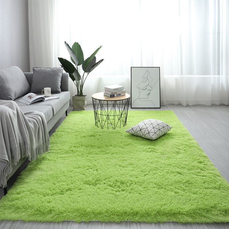 Living room with a green rug, gray sofa, and decorative items.