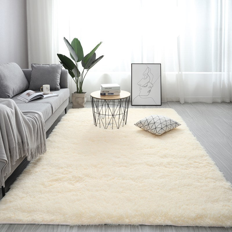 Living room with a beige rug, gray sofa, and decorative elements.
