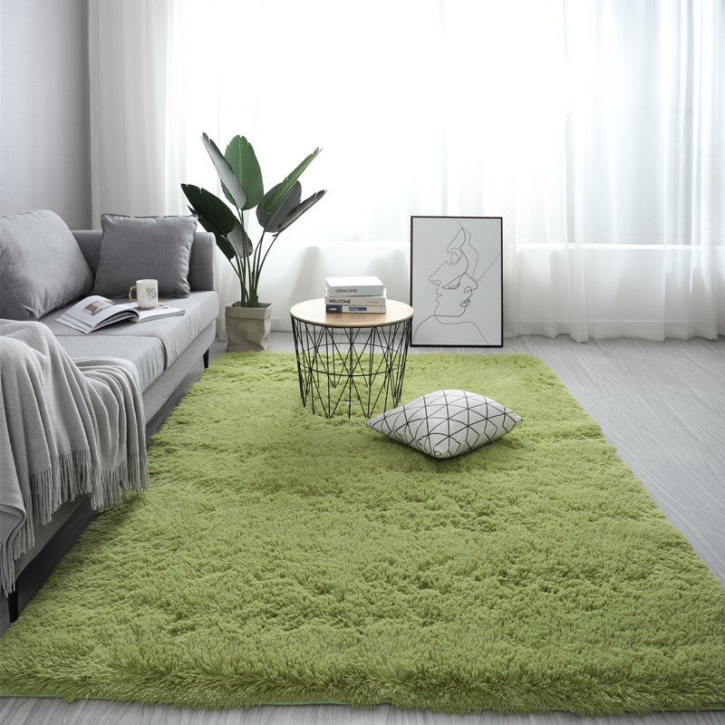 Living room with a green rug, gray sofa, and decorative items.