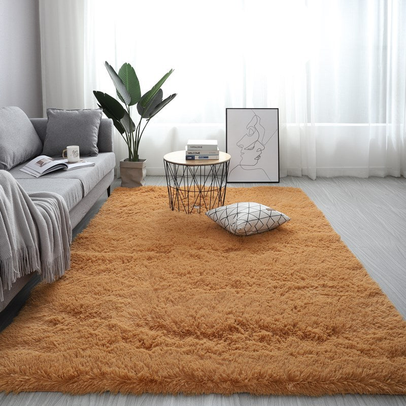 Living room with a brown rug, gray sofa, and decorative items.