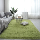 Living room with a green rug, gray sofa, and decorative items.