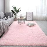 Living room with a pink rug, gray sofa, and decorative elements.