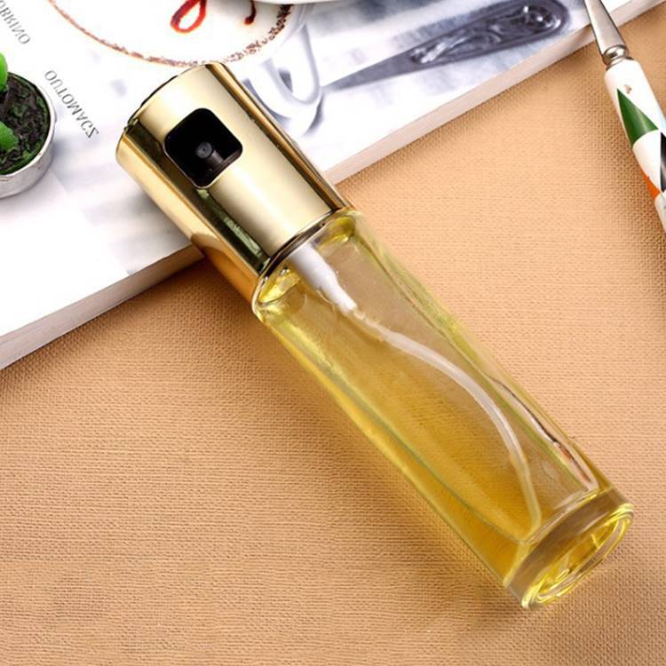 Clear spray bottle with gold top on a textured surface