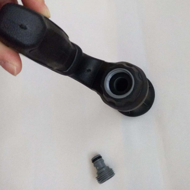 Black mechanical component held by a hand on a white background