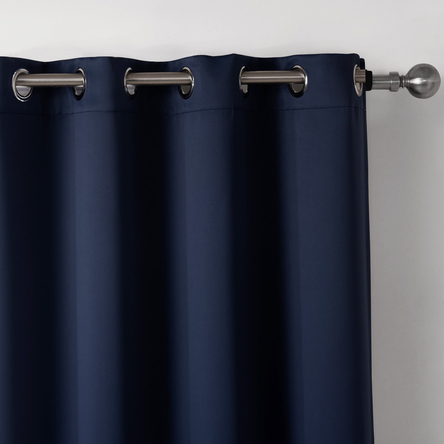 Navy blue curtain with silver grommets on a plain background