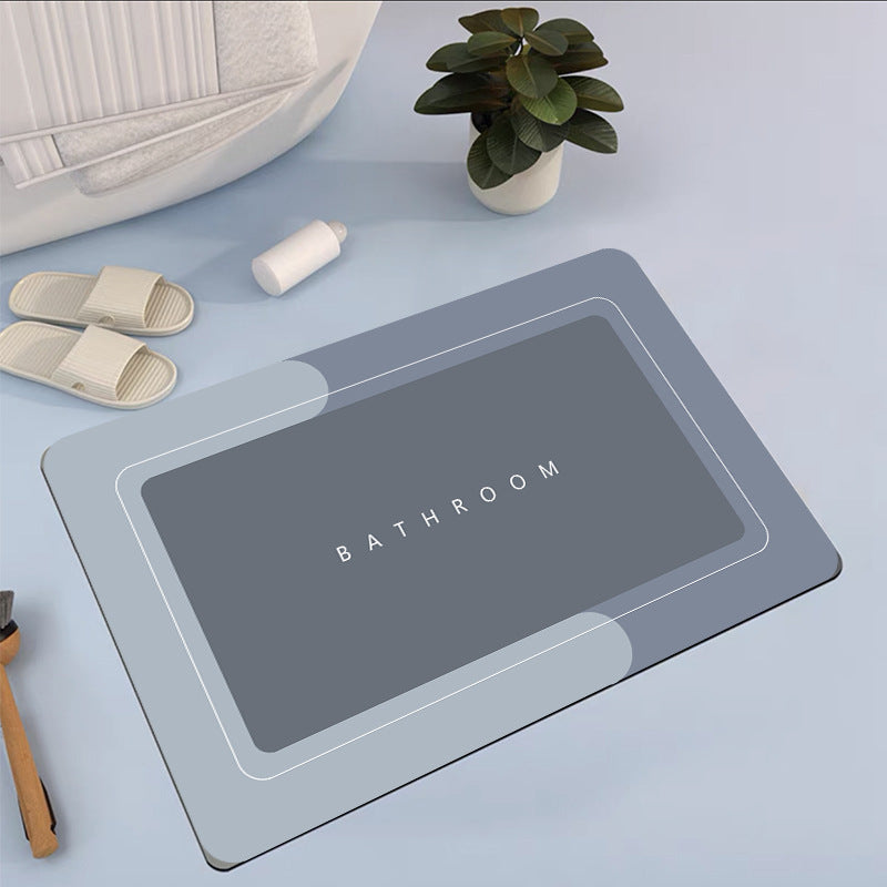 Gray bath mat with 'Bathroom' text on a light blue surface, surrounded by bathroom items.