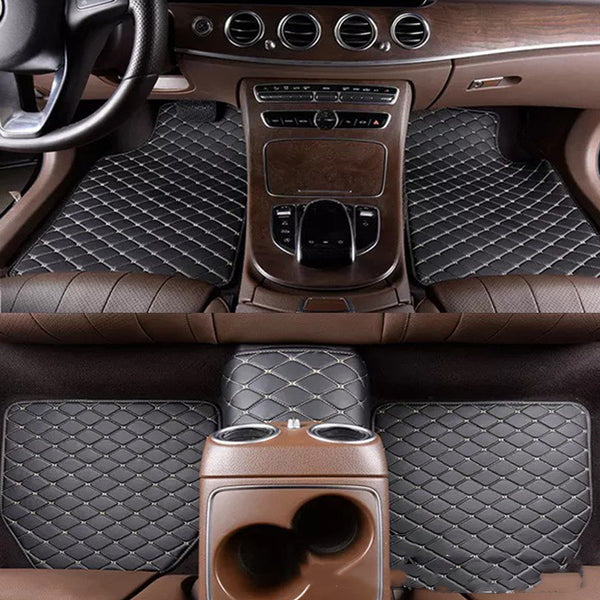 Car interior with quilted black floor mats and brown dashboard.