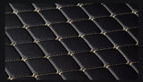 Black quilted leather surface with gold stitching