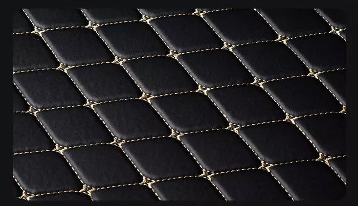 Black quilted leather surface with gold stitching