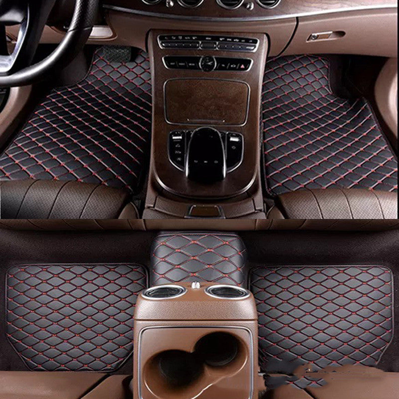 Car interior with diamond-patterned black and red floor mats.