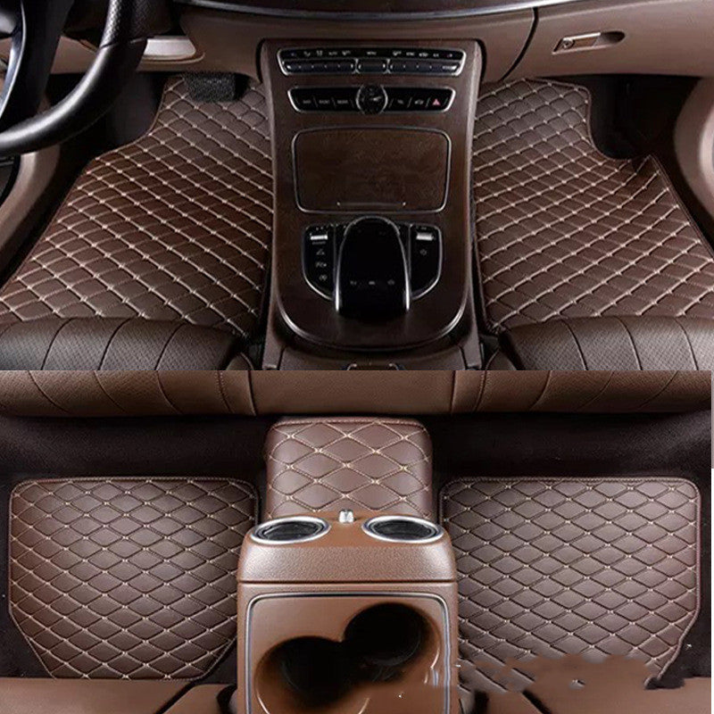 Brown car interior with quilted design on floor mats and center console.