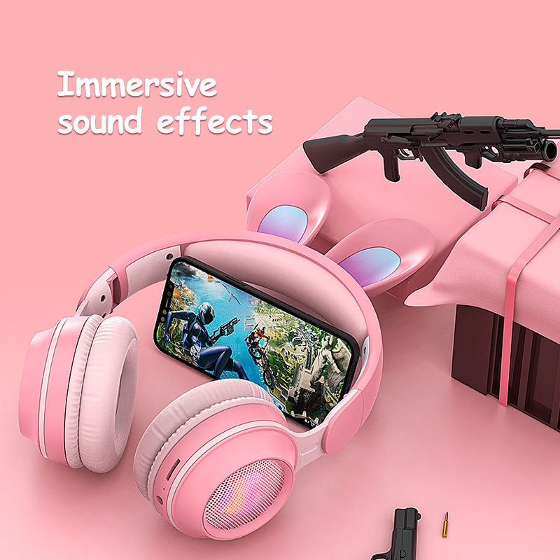 Pink gaming headset with screen, gun, and accessories on a pink background with 'Immersive sound effects' text.