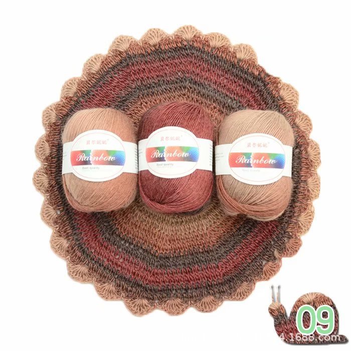 Three skeins of yarn in brown and red tones on a knitted coaster with a snail logo in the corner.
