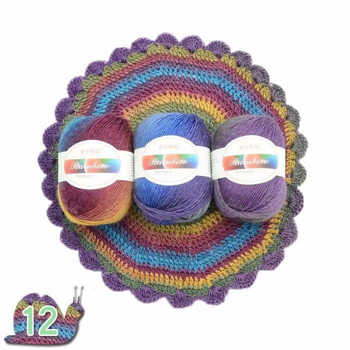 Three skeins of colorful yarn on a crocheted rainbow-patterned surface with a small calendar indicating the number 12.