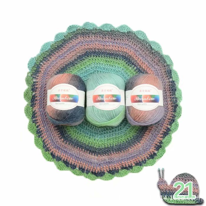 Three balls of yarn with 'Rainbow' labels on a crocheted multicolored mat.