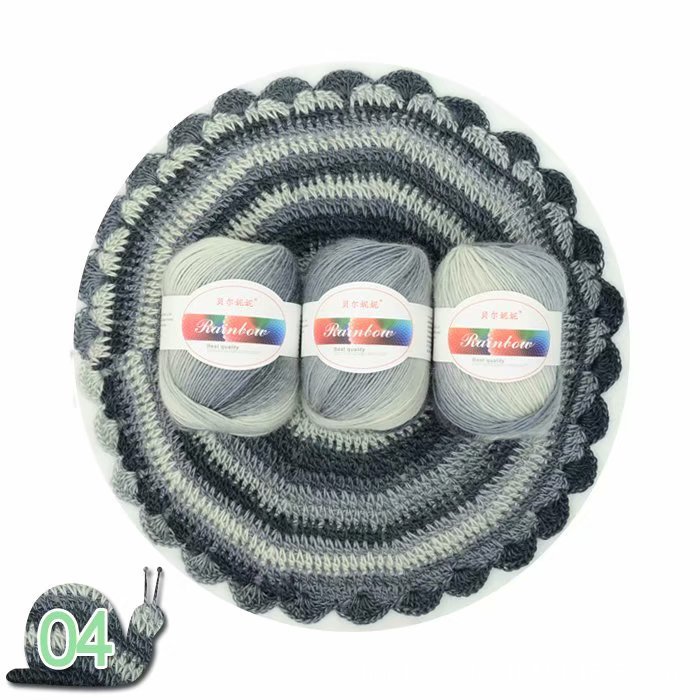 Three balls of yarn with labels inside a crocheted yarn bowl on a white background