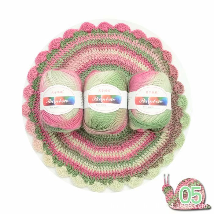 Three skeins of pink and green yarn with a knitted product and a small snail-shaped container on a white background.