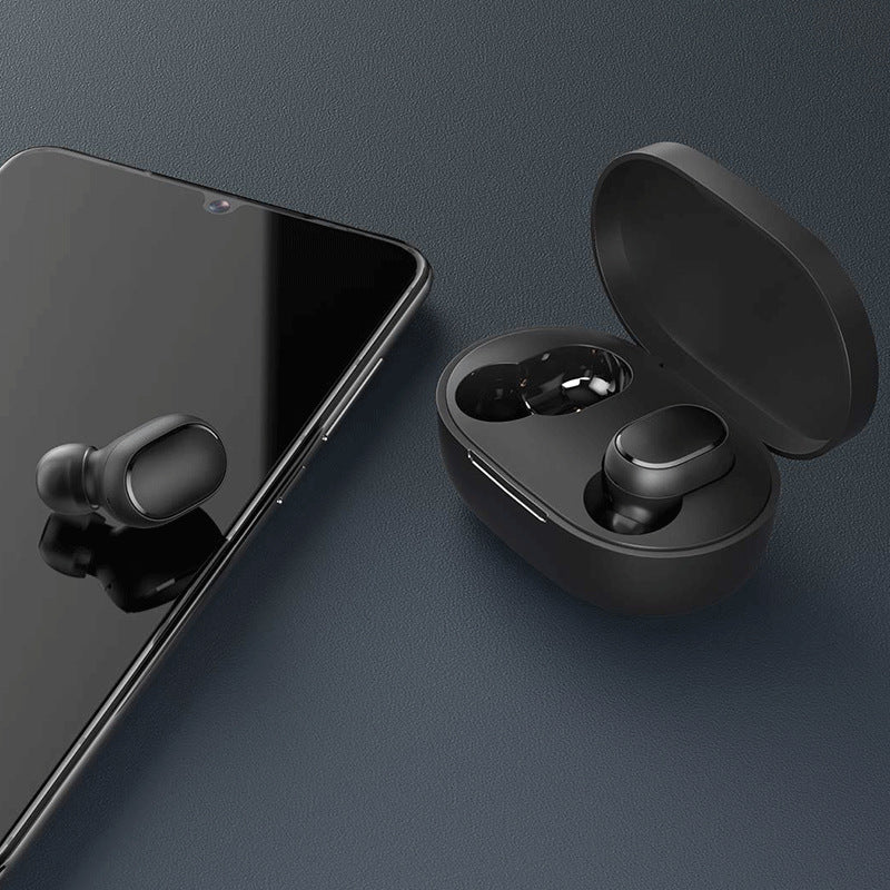Black wireless earbuds with charging case on a dark surface