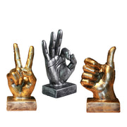 Three decorative hand sculptures in different poses on wooden bases against a white background