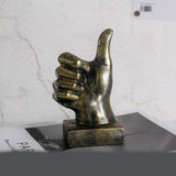 Bronze hand sculpture giving a thumbs-up on a marble surface