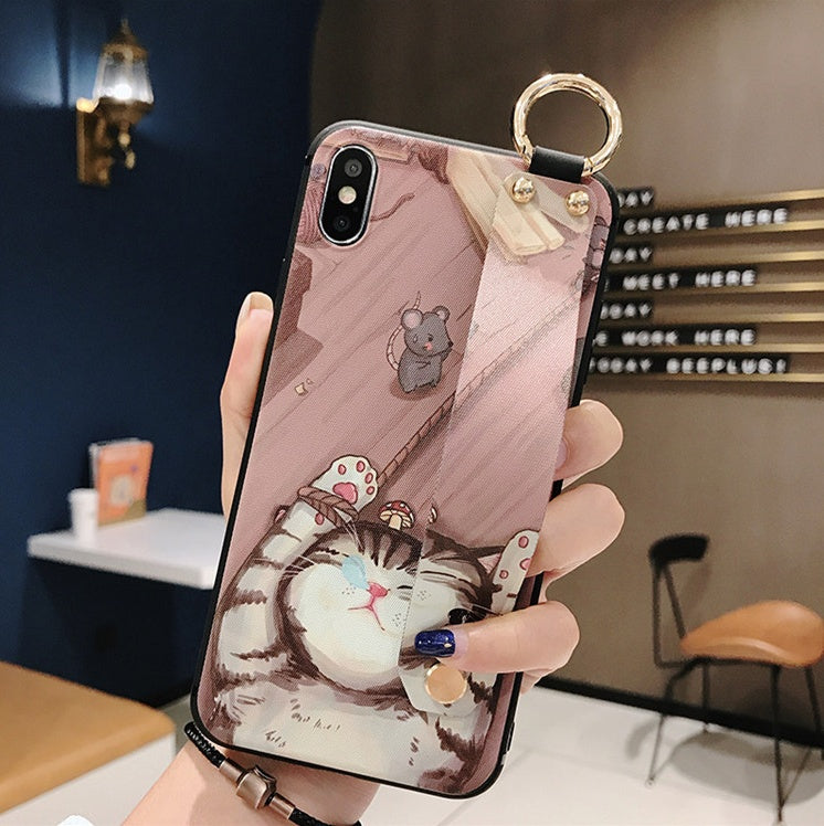 Phone case with a cat design held by a hand in an indoor setting