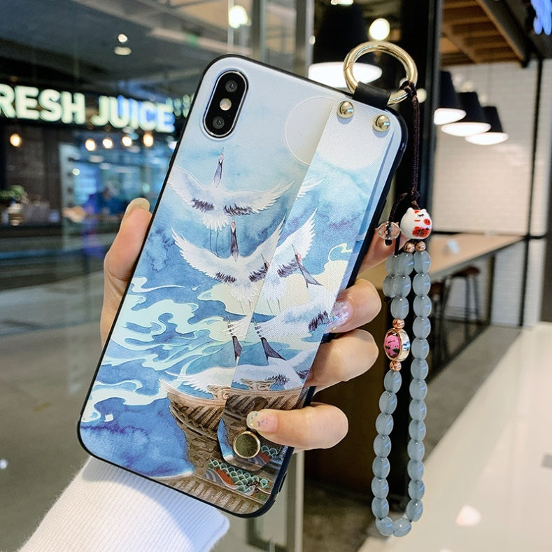 Phone case with crane design held by a hand in an indoor setting