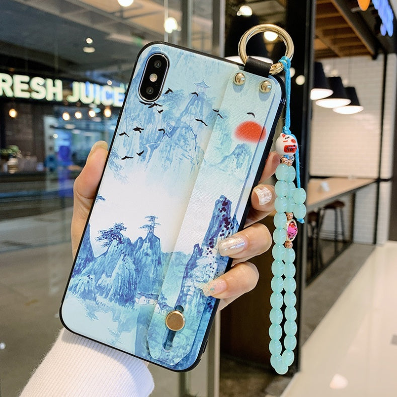 Phone case with scenic design held by a hand in an indoor setting