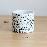 Ceramic pot with terrazzo pattern on a wooden surface, showing measurements.