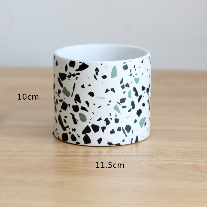 Ceramic pot with terrazzo pattern on a wooden surface, showing measurements.