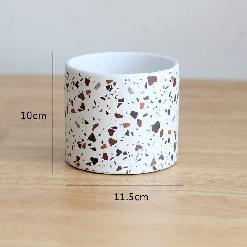 Cylindrical container with terrazzo pattern on a wooden surface, showing measurements.