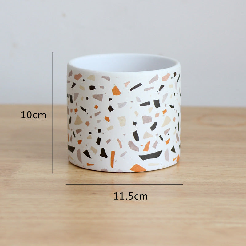 Ceramic pot with terrazzo pattern on a wooden surface, showing measurements.