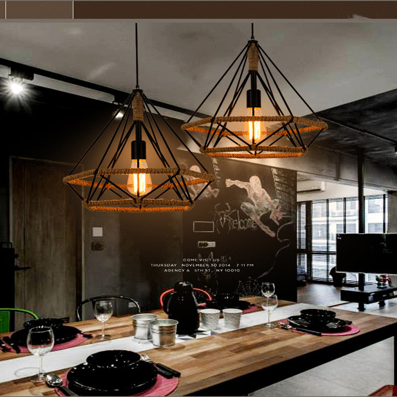 Two pendant lights hanging above a dining table in a modern interior setting.