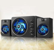 Black computer speakers with blue LED lights on a reflective surface