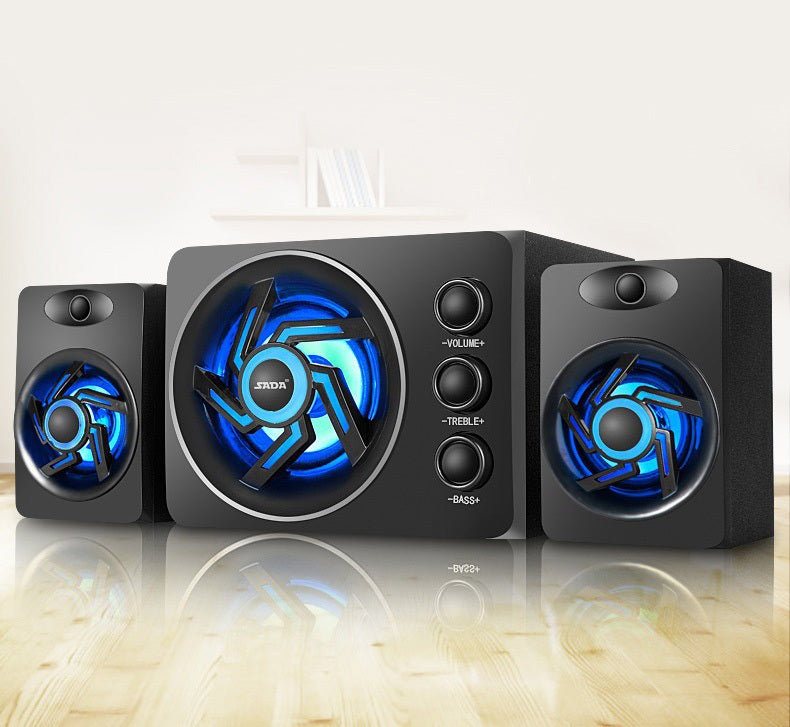 Black computer speakers with blue LED lights on a reflective surface