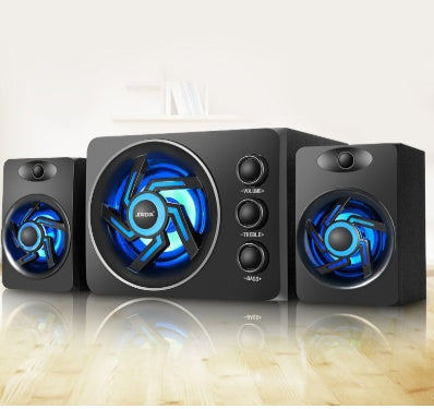 Black computer speakers with blue LED lights on a reflective surface