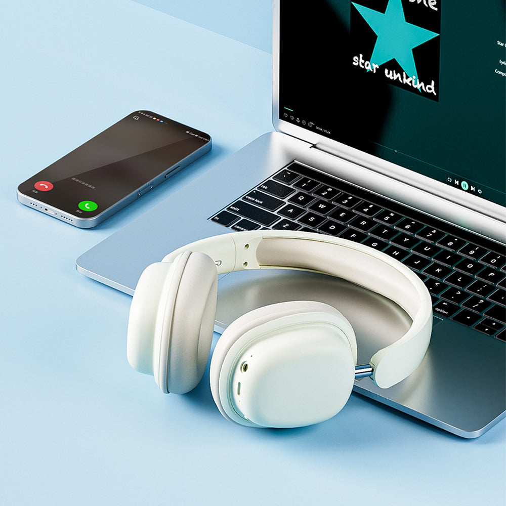 White headphones on a laptop with smartphone and 'star unkind' app icon on screen