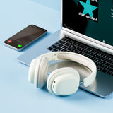 White headphones on a laptop with smartphone and 'star unkind' app icon on screen
