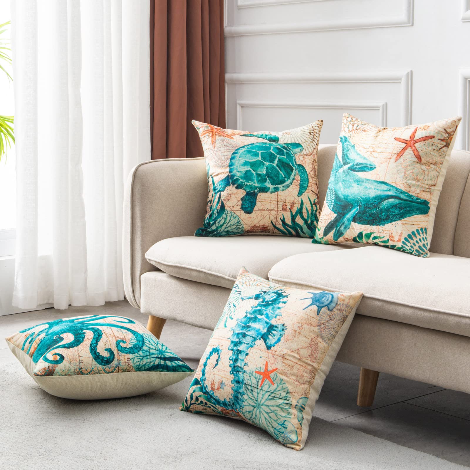 Decorative pillows with sea-themed designs on a beige sofa in a living room.