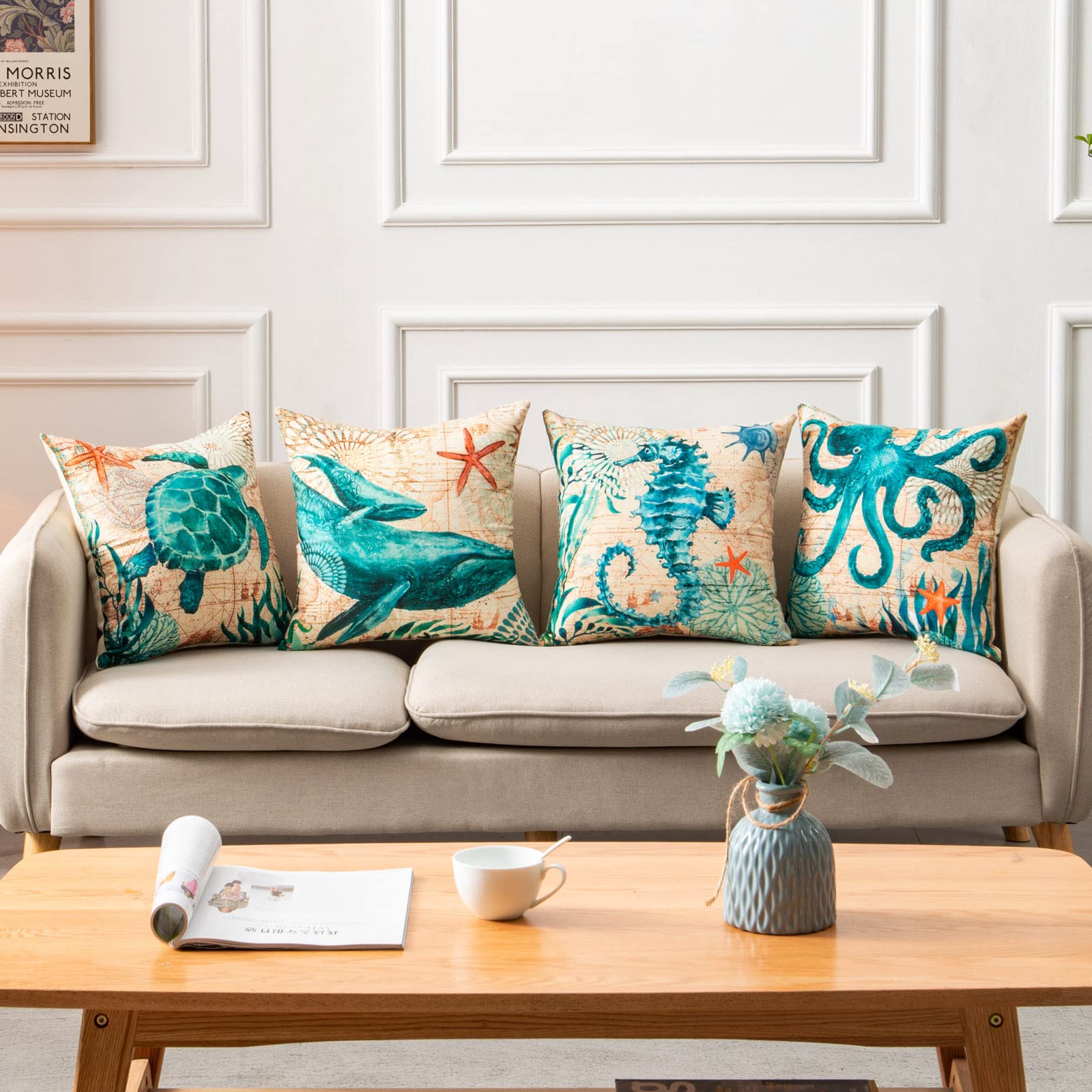 Sofa with decorative pillows featuring sea creatures, a coffee table with a cup and magazine in a living room setting.