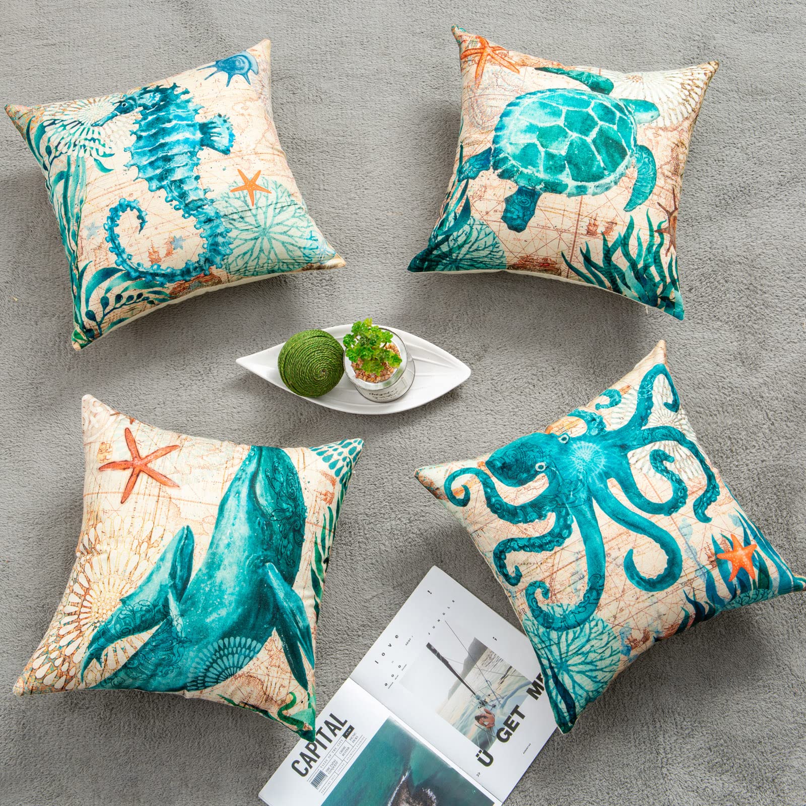 Four decorative pillows with ocean-themed designs on a gray surface.