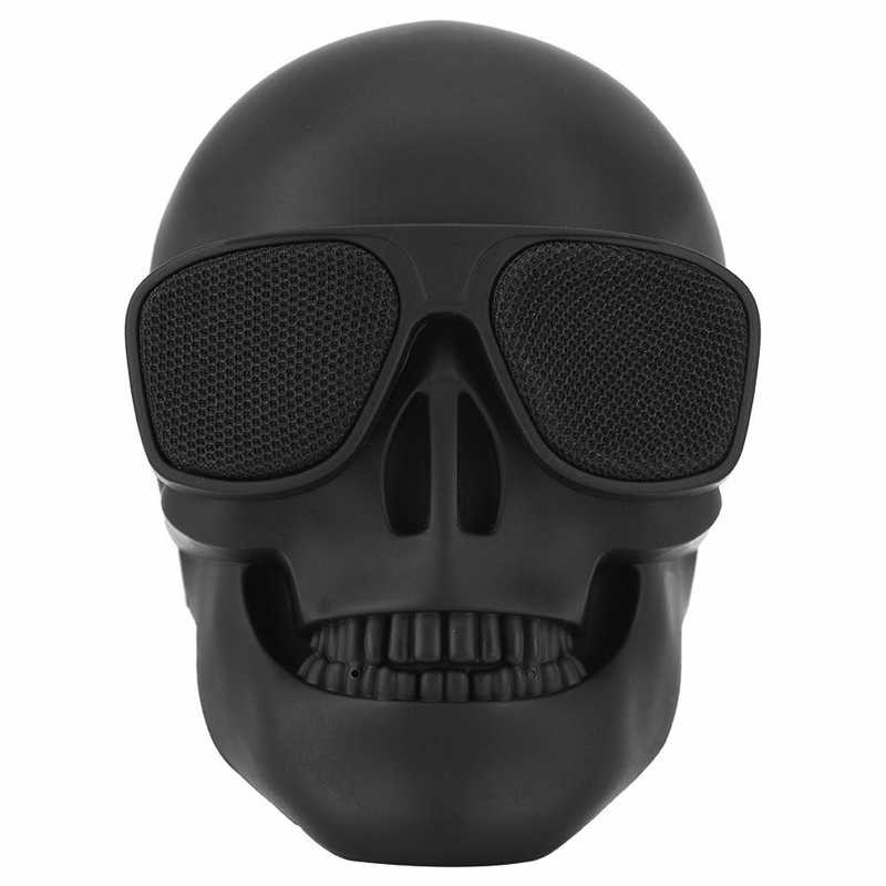 Black skull-shaped speaker with sunglasses on a white background