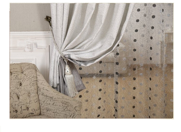 Decorative curtain with tassel and patterned fabric on a neutral background