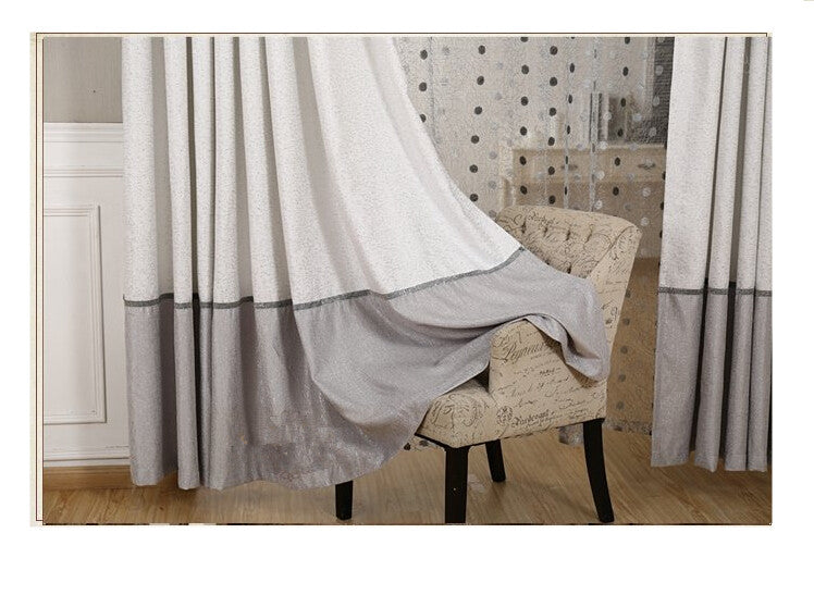 Gray and white curtain draped over a chair in a room with a patterned wall.