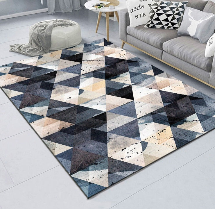 Geometric patterned rug on a light gray floor with a sofa and coffee table in the background.