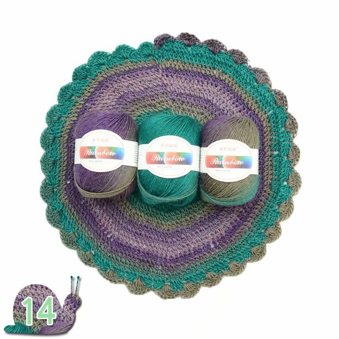 Three balls of yarn in purple and green on a matching crochet coaster with 'Artistic' label.