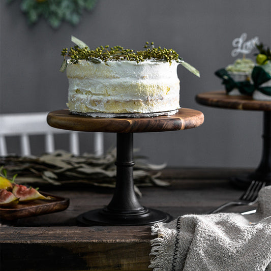 Decorative cake on a wooden stand with a neutral background