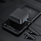 Black wireless earbuds charging case with earbuds on a dark surface